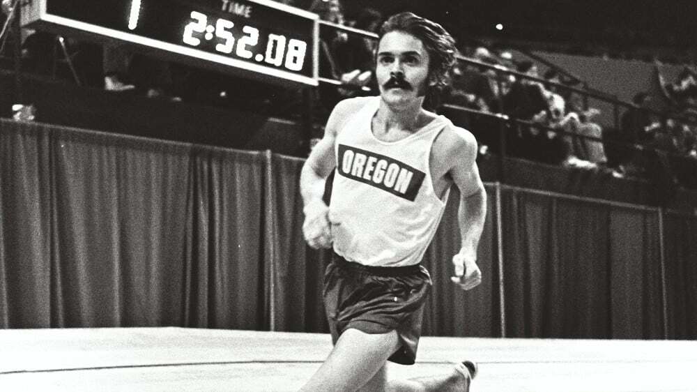 A male runner in an "Oregon" jersey races indoors, exemplifying a winning brand, with a digital timer showing 2:52.08 in the background. Consensus