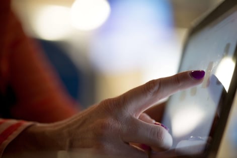 Woman's hand touches a computer tablet