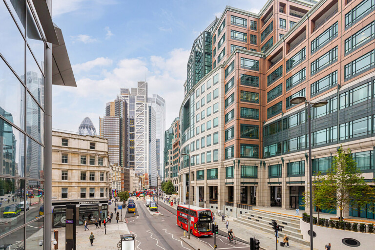 A bustling city street in London 2023 featuring tall buildings and a double decker bus showcasing the vibrant energy of DEMOFESTx.