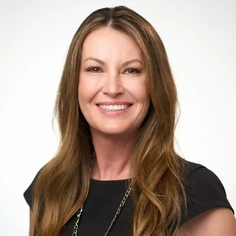 A smiling woman in a black top.