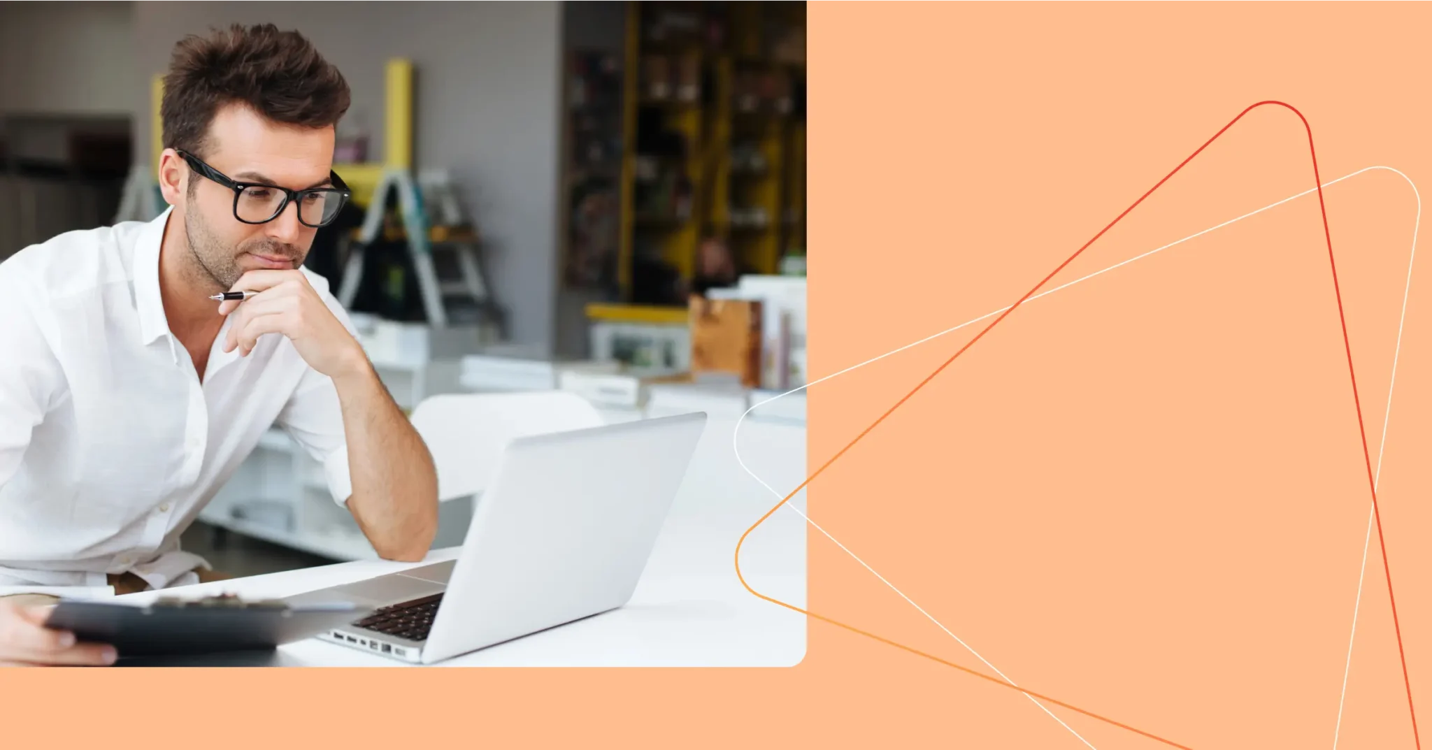 Man in glasses sitting at a desk, looking at a laptop screen and holding a clipboard, with an orange graphic background on the right. Consensus